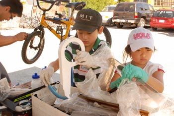 Father and two children repairing a bicycle