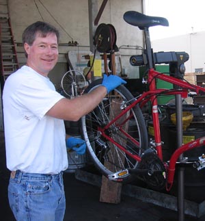 Man repairing a red bicycle